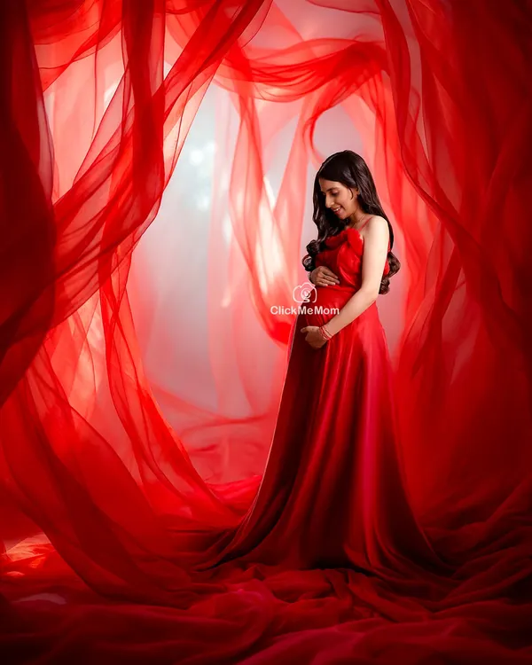 This is the moment I strive to capture. The pure elegance of motherhood, wrapped in a bold color that celebrates your strength. This portrait uses flowing fabrics to create a dramatic and timeless feel, focusing entirely on the beautiful connection between you and your baby bump.