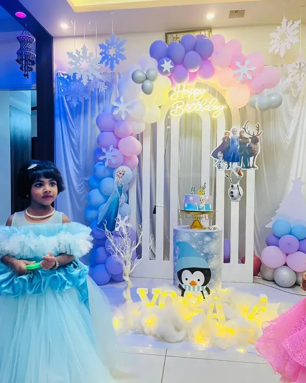 A beautiful home-based setup for a Frozen themed birthday party. We used a pastel balloon arch, a custom neon "Happy Birthday" sign, and character cutouts to transform the space into a winter wonderland.