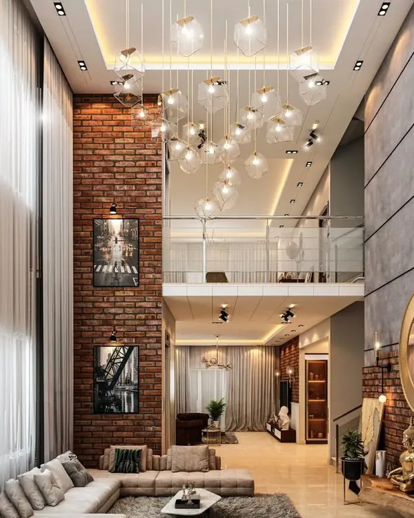 This duplex living room showcases our ability to design for grand, double-height spaces. The exposed brick wall adds an industrial-chic texture, while the cluster of pendant lights draws the eye upward, creating a space that is both impressive and inviting.