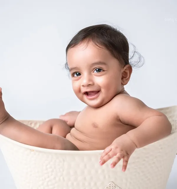 Pure happiness in a tub! This simple and joyful shot captures the fun of a splash session, a favorite part of the first birthday photoshoot experience.