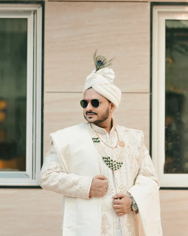A stylish portrait of the groom. We capture the groom's personality and dapper style, complete with sunglasses and a peacock feather on his safa.