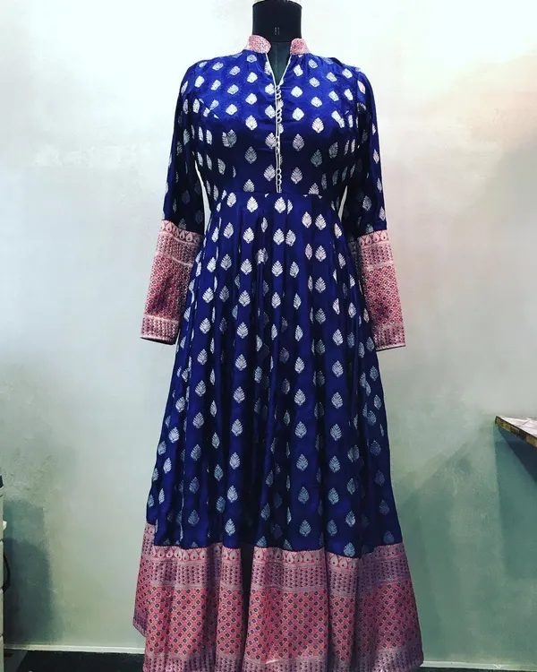 A grand Anarkali stitched from a royal blue brocade saree. The design includes a high neck and uses the saree's pallu for the contrasting cuffs, perfect for weddings.
