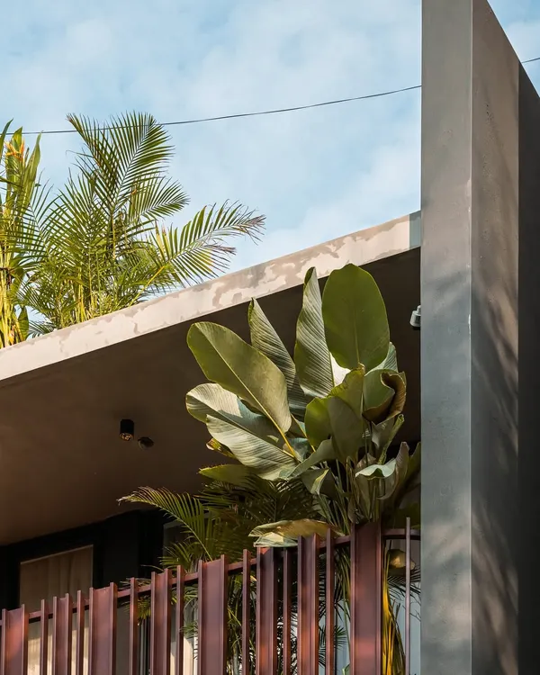 The cantilevered roof of the 'Ittige' residence provides shade while allowing lush tropical plants to thrive, blurring the line between the building and its garden.