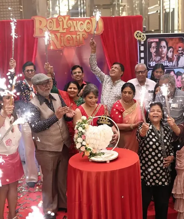 Lights, Camera, Action! For a 60th birthday, I designed a 'Bollywood Night' theme, complete with a red curtain backdrop, film reel details, and sparklers for a dramatic cake-cutting moment.