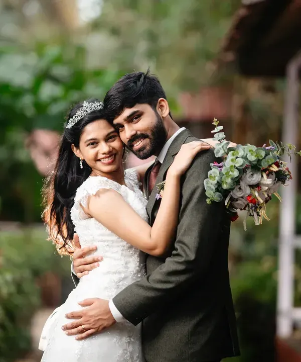 A classic, romantic portrait from a Goa wedding. The soft natural light and lush green background create a serene setting for this simple, affectionate embrace.