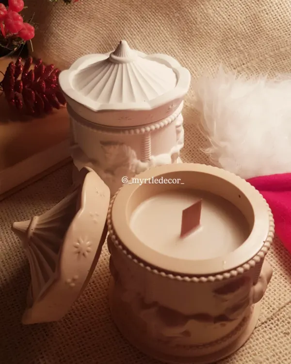Our Carousel Christmas jar candle, shown here with its lid off to reveal the hand-poured soy wax and wooden wick inside. The intricate carousel horse details on the Jesmonite jar are meant to evoke a sense of nostalgia and festive wonder.