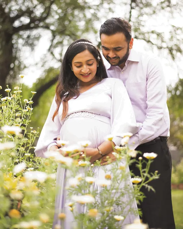A beautiful candid moment between expectant parents, surrounded by wildflowers in a sunlit garden. I love capturing these shared glances and gentle interactions that tell the story of their journey together.