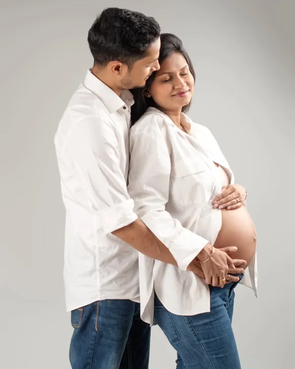 A quiet, intimate moment shared between partners. I gently guide couples into poses that feel natural, capturing the love and support that surrounds your growing baby bump in a simple, classic studio setting.