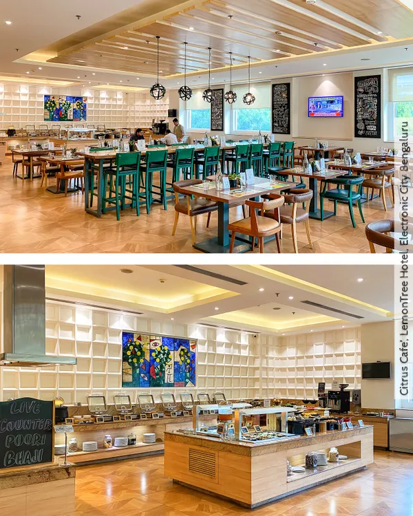 The Citrus Cafe at Lemontree Hotel, Bengaluru, is a bright and lively all-day diner. The design features a mix of seating types, including high tables and a large community table, set against a backdrop of textured white walls and vibrant art.