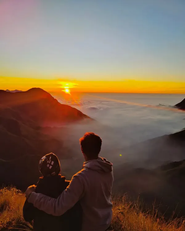 A couple watching the sunrise over a blanket of clouds in Munnar. This is the kind of romantic and peaceful moment my trips are made for.