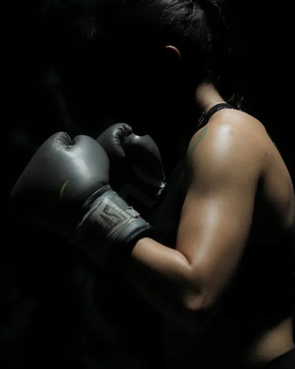 The focus and determination of a boxer. This shot captures the intensity of our boxing training, where you learn to channel your strength and energy into powerful, controlled movements.
