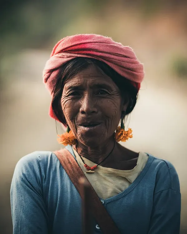 A warm, intimate portrait of an elderly woman with a gentle smile, showcasing the ability to capture character and emotion in environmental portraiture.