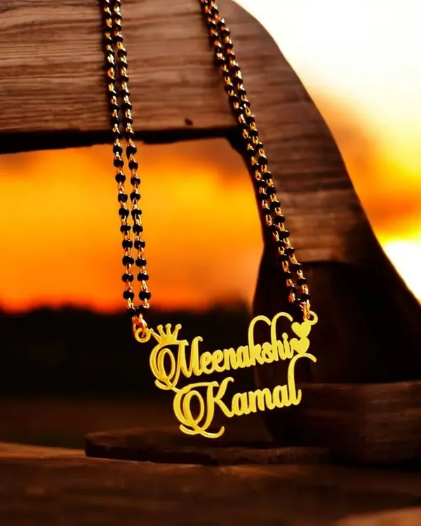 A beautiful way to celebrate your bond, this custom double-name pendant is designed in a mangalsutra style with traditional black beads. The elegant script and decorative crown and heart details make it a truly special piece for couples.