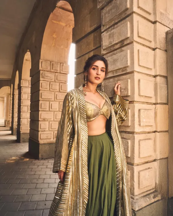 This look is all about making a statement. I paired a shimmering gold bralette and a modern olive lehenga with a structured, striped jacket to create a powerful fusion silhouette that’s perfect for a festive evening or a wedding reception.