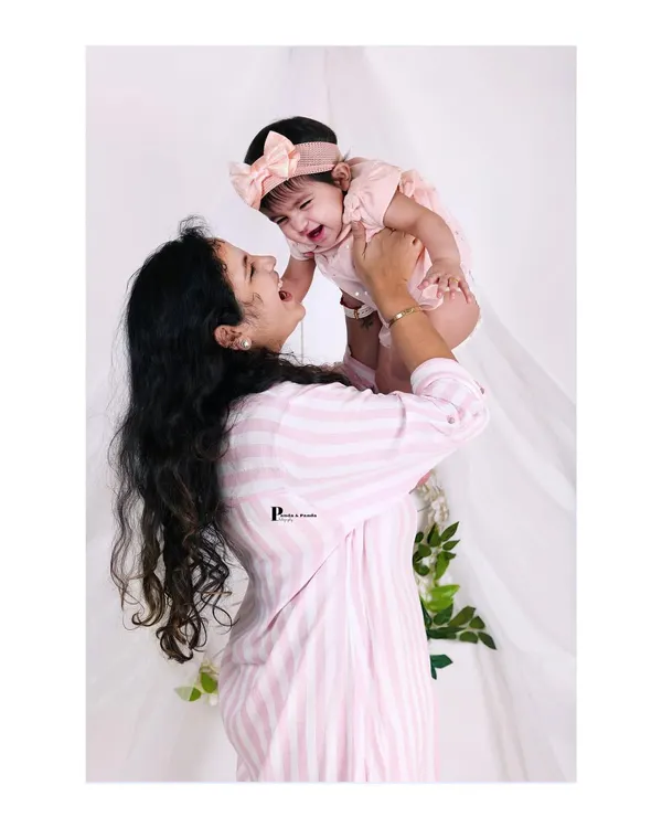 A candid, joyful moment as a mother lifts her baby girl. We love capturing these spontaneous interactions that show the true happiness of motherhood.