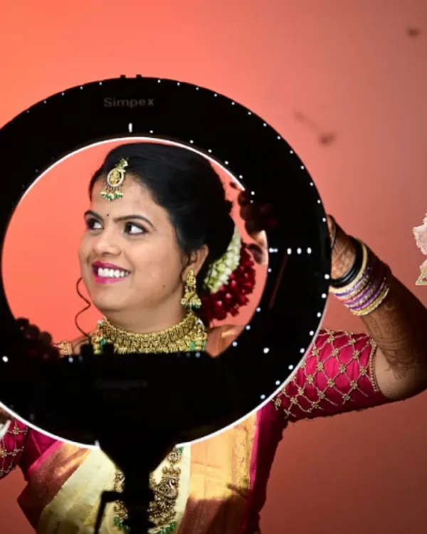 A happy bride ready for her Muhurtham. This professional shot, taken with a ring light, highlights the smooth, natural-finish HD makeup that ensures she looks perfect from every angle.