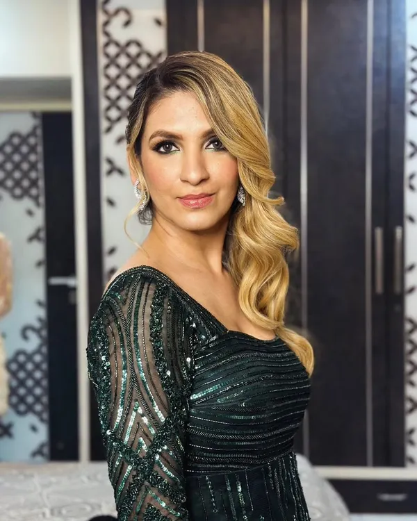 This one-shoulder gown in a trendy emerald green is a perfect example of my detailed handwork. The bodice and sleeve feature intricate, intersecting lines of self-colored cutdana, sequins, and salis for a sophisticated, modern look.