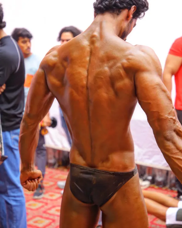 A detailed back shot. This pose shows the separation and density of the spinal erectors, lats, and traps, all crucial for a winning back pose.