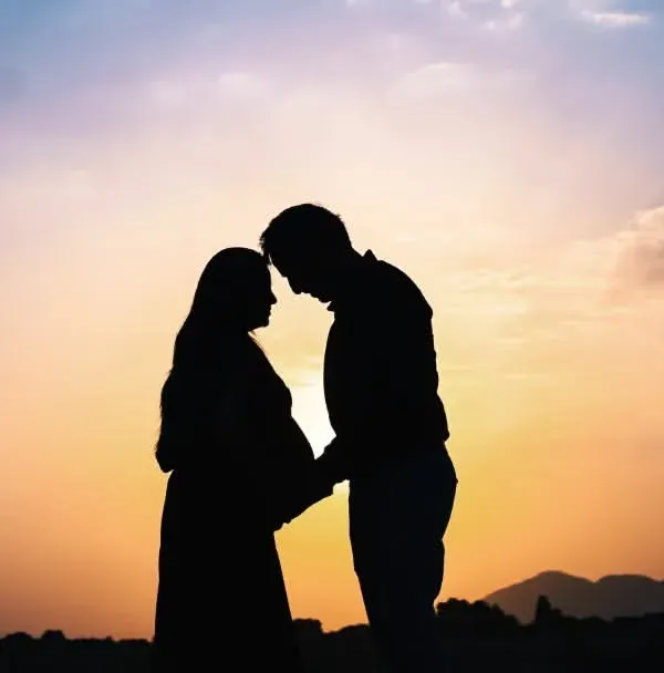 This is the magic we chase. A quiet moment for the two of you against a beautiful sunset sky, creating a timeless silhouette that’s all about your connection before the little one arrives.