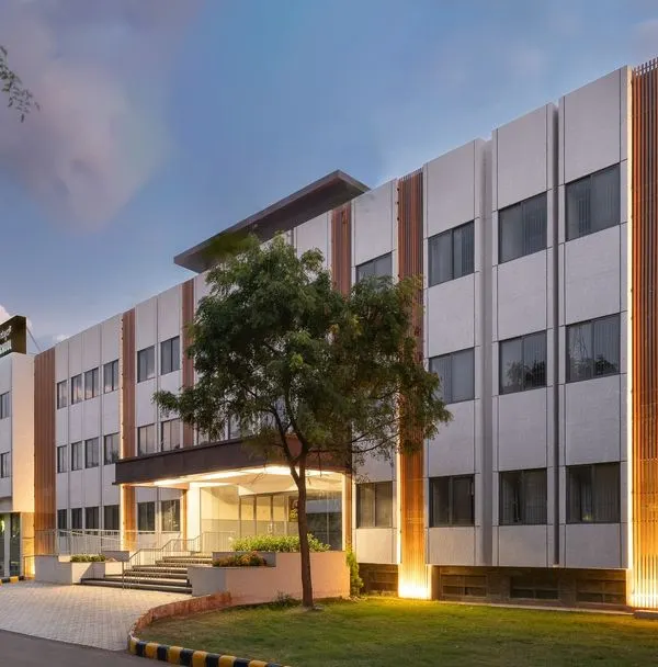 The Jindal Public School in Dabaspet, a project designed to provide free, quality education in a modern campus that rivals private institutions. The facade lighting highlights the architectural details, creating a welcoming beacon for the community at night.