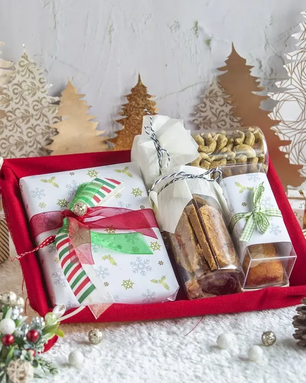 A festive red tray hamper for Christmas, filled with a delightful assortment of cookies, nuts, bar cakes, and other treats. Perfect for gifting or sharing at holiday parties.