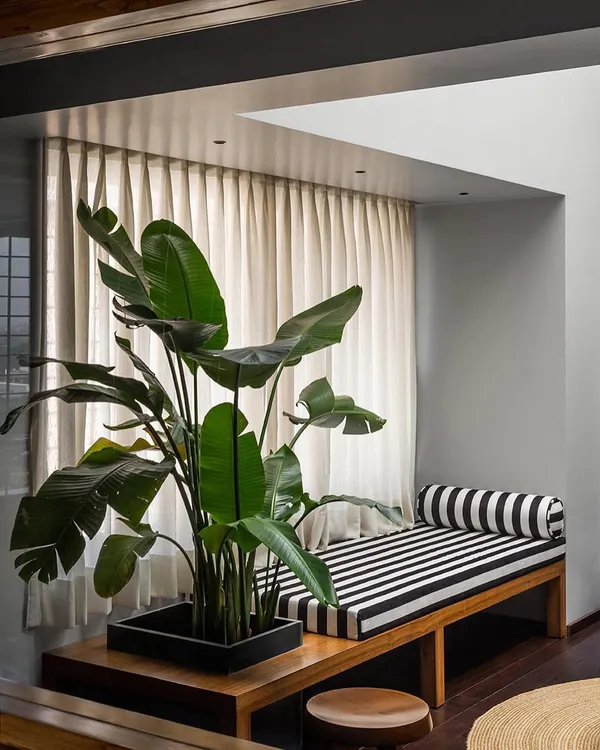 This custom timber bench in the Pink Marble House features an integrated planter box, literally bringing greenery into the master bedroom lounge. The striped cushion adds a graphic touch to this sun-drenched spot under a skylight.