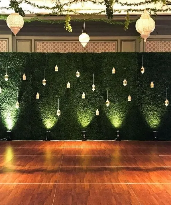 I created this elegant event backdrop using a large artificial hedge wall. Decorated with hanging lanterns and uplighting, it provides a beautiful and sophisticated photo opportunity for weddings, parties, or corporate events.