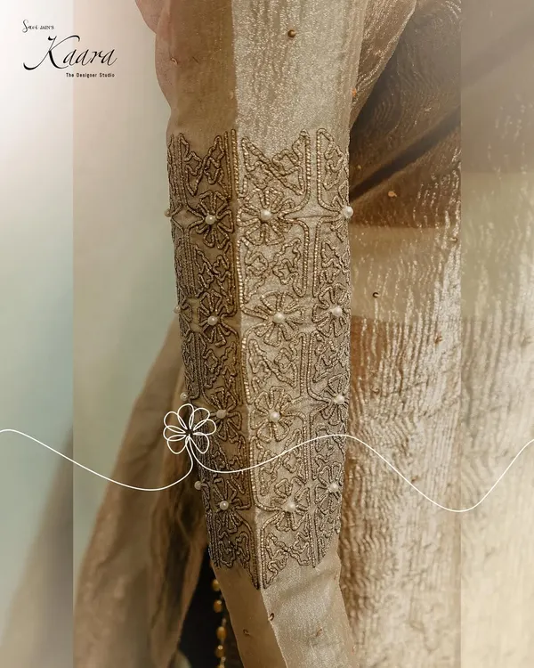 A close-up of the sleeve of a net kurti, showing the intricate sequin and pearl detailing. This kind of hand-stitching is what gives each of my creations its unique character and elegance.