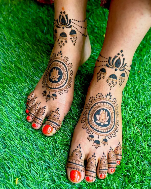 This design features a bold lotus mandala on the top of the foot, paired with traditional jhumka and lotus motifs around the ankle for an ornate finish.