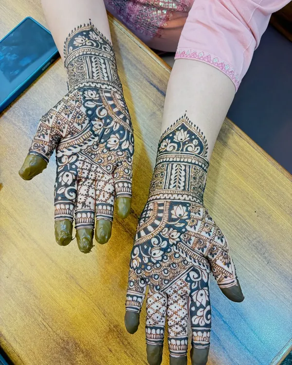 A beautiful Arabic-style design on the back of the hands. The pattern is dense with bold floral motifs and delicate shading, creating a striking contrast.