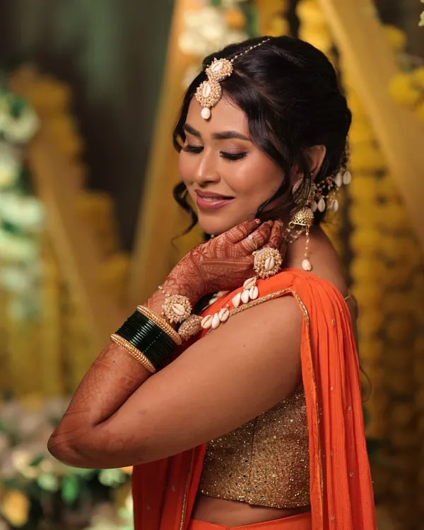 A splash of orange, a dash of glow. This Haldi makeup look is all about radiant skin, shimmery eyes, and a fun, messy braid that steals the show.