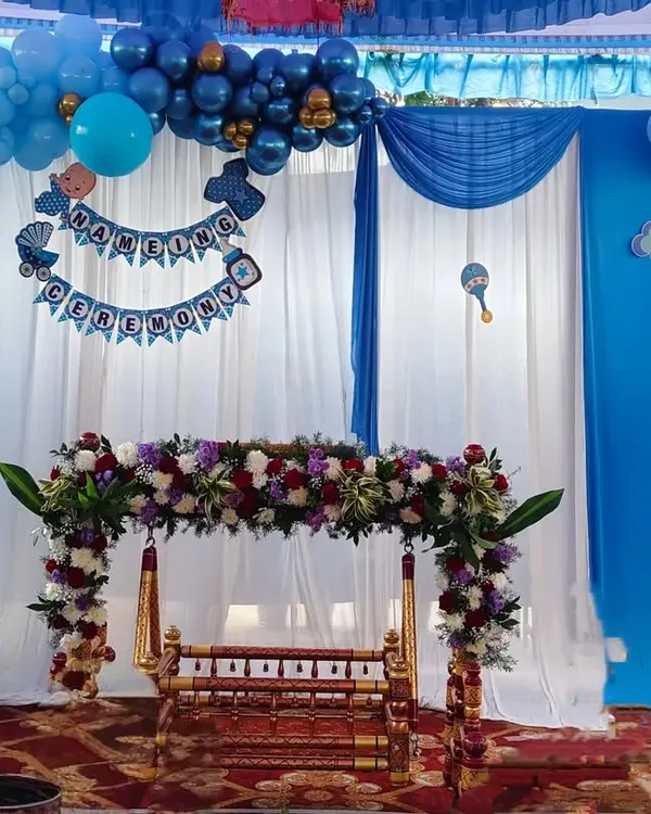 Here is a beautiful setup for a traditional Namakarana or naming ceremony. We decorated the wooden cradle, or thottilu, with fresh flowers and created a backdrop with blue balloons and soft white drapes to welcome the little one.