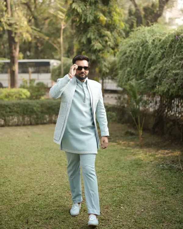 Dressed to impress without the stress. Our client looks sharp in this pastel blue open-jacket Indo-Western outfit, a modern and stylish choice for a groom or groomsman.