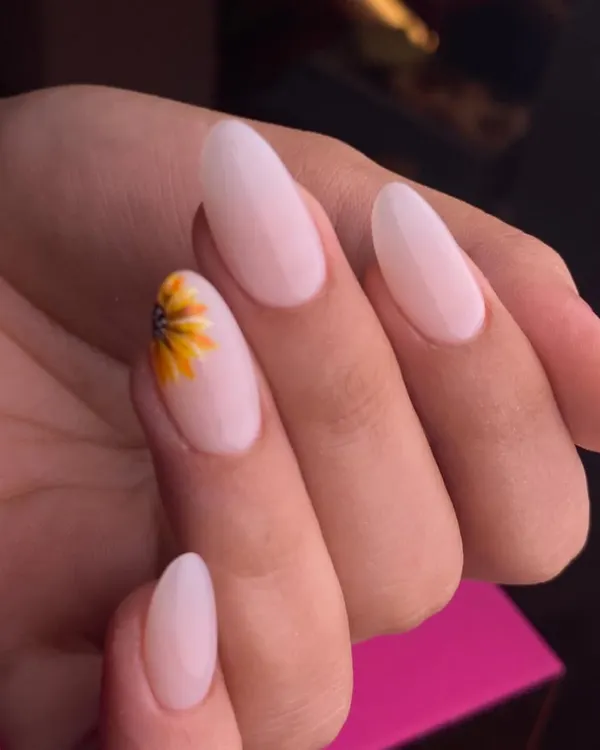 A touch of sunshine for your fingertips. This minimalist design features a delicate, hand-painted sunflower on a single accent nail, set against a clean, milky-white base on beautifully shaped oval nails.