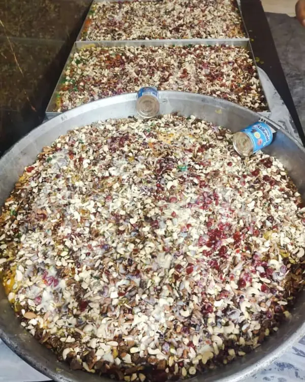Huge platters of our special sweet dish, likely Shahi Tukda or a bread pudding, loaded with nuts and tutti-frutti.