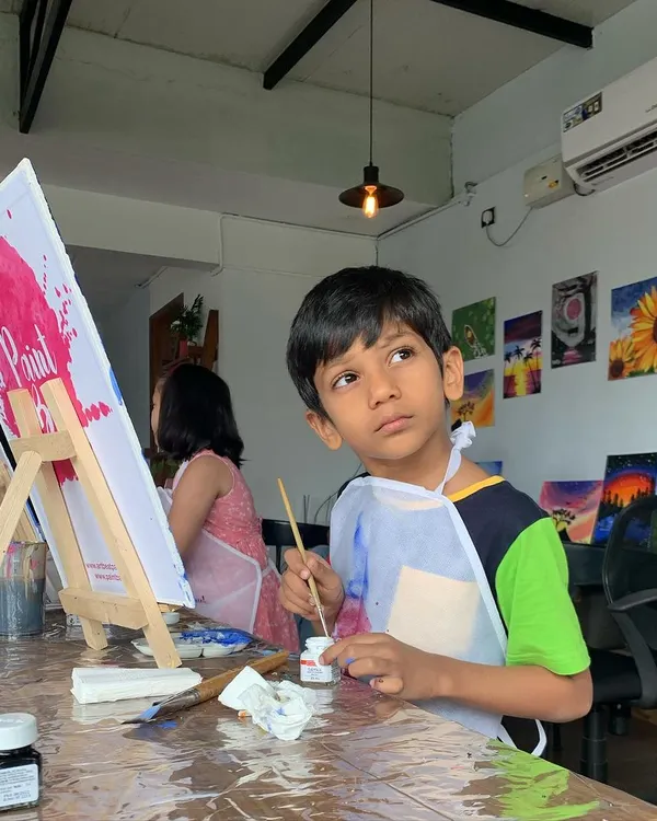 A young artist deep in thought, contemplating his next brushstroke. It's pure joy watching young minds dive into a world of color and creativity.