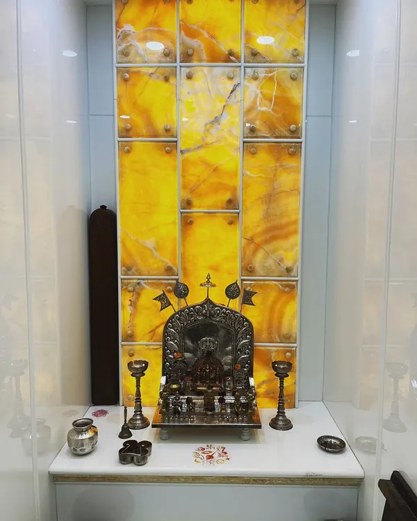 We enhanced this pooja room with a backlit panel of golden Onyx marble. The natural veining of the stone creates a unique, divine glow, making the sacred space feel serene and special.