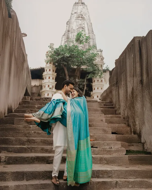 A joyful moment captured against the timeless architecture of the Banganga Tank in Mumbai. This style of pre-wedding shoot blends cultural heritage with modern romance, creating images that feel both grand and deeply personal.