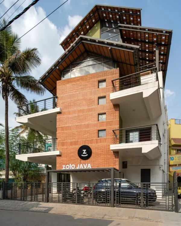 This is the completed exterior of the Earthen Spirit project, a warehouse we repurposed into a modern co-living space called Zolo Java. We added new balconies and a striking multi-layered roof structure, blending the building's industrial past with a fresh, residential feel. The final design stands as a testament to how adaptive reuse can revitalize urban structures.