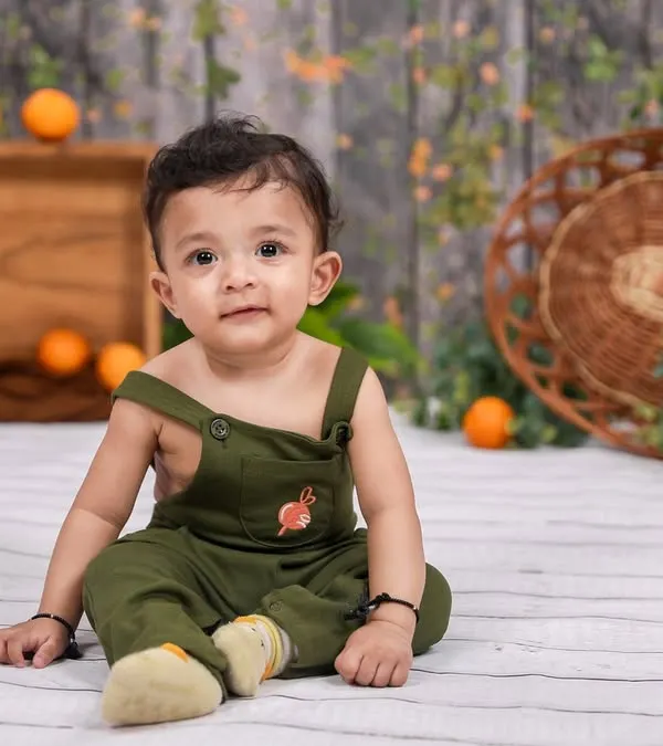 A classic sitter session portrait. This little one is sitting up proudly in our studio, with a simple, rustic background that keeps all the attention on his adorable face.