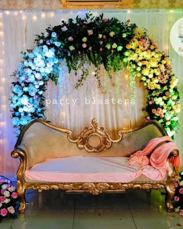 A gorgeous floral arch for an engagement ceremony. The semi-circular arch is covered in a rainbow of flowers, creating a vibrant and joyful backdrop for the happy couple.