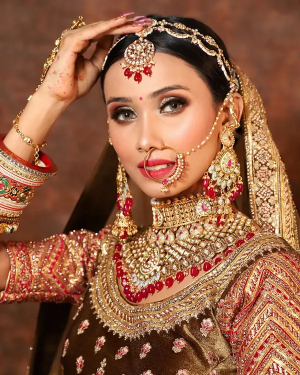 This is the ultimate bridal look. A heavy, multi-layered Kundan and Polki set with red bead detailing, complete with a matching maang tikka, sheesh patti, nath, and hathphool. It’s designed to make you feel like royalty on your wedding day without the hefty price tag.