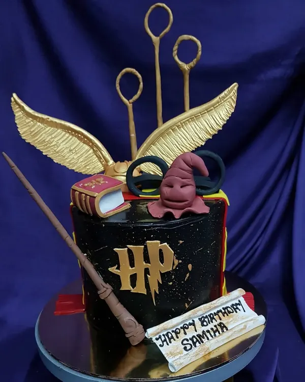 Wingardium Leviosa! This Harry Potter themed cake is pure magic, featuring an edible Sorting Hat, golden snitch, and magic wand. It's the perfect centerpiece for any Potterhead's birthday celebration.