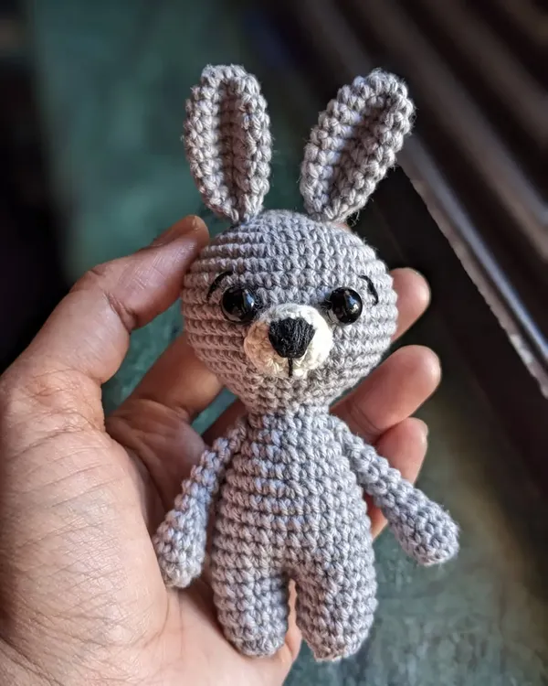 A tiny grey bunny keychain, small enough to fit in your hand but full of personality.