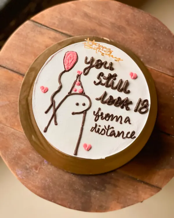 A hilarious birthday cake with a stick figure and the message, "you still look 18 from a distance." This custom cake is in my popular Nutella Ferrero Rocher flavor.