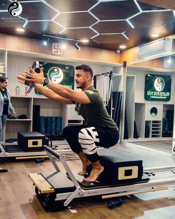 Pilates is not just for women. Here, a male client works on a challenging squat variation, building lower body strength and balance. My classes are designed for everyone.
