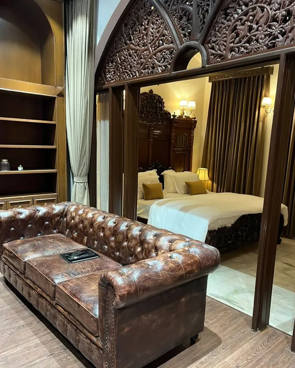 I love blending classic Indian aesthetics with luxurious comfort. This bedroom showcases our expertise in sourcing and integrating timeless pieces, like this intricately carved wooden headboard and archway, to create a space that feels like a royal heritage suite.