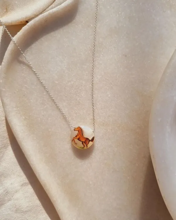 This is "Oliver's Horse," a talisman I had hand-painted on a white moonstone pendant. The horse symbolizes freedom and strength, while moonstone is for emotional stability and new beginnings.