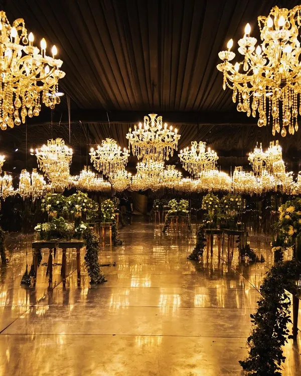 I transform grand ballrooms into ethereal dreamscapes. Here, a universe of crystal chandeliers floats above a reflective floor, creating an infinite golden glow for a truly breathtaking reception.