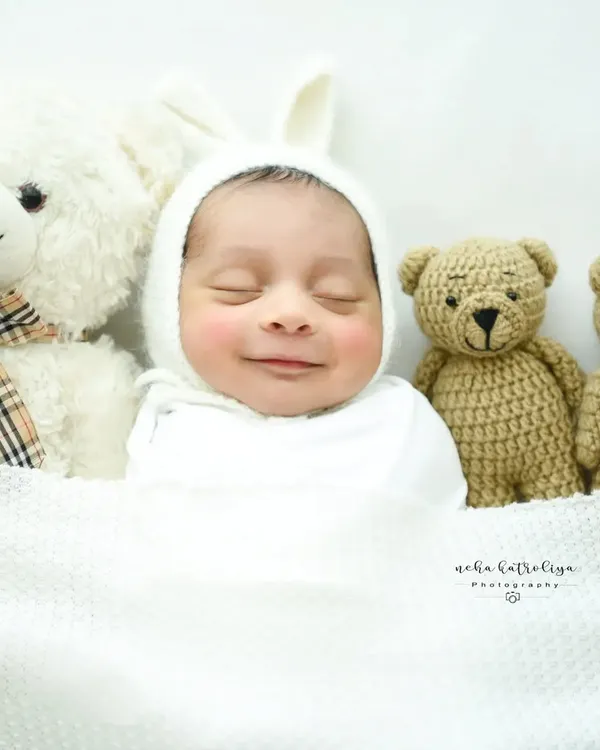 That heart-melting newborn smile. I live for these moments of pure, sleepy joy. This little one is wrapped cozily in a white bunny bonnet, ready for a sweet dream.